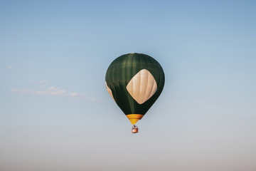 A green hot air balloon in the morining sky