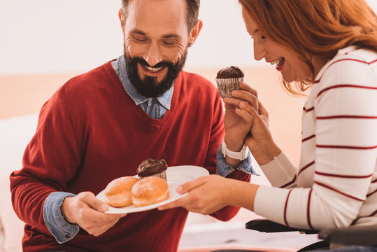 Sweet Teeth. Joyful Mid Aged Couple Eating Dessert While Resting Together At Home