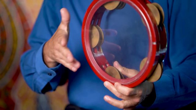 Closeup of hands playing clear riq with beladi rhythm.