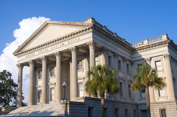 An old (mid 1800s) US government customs house with typical neoclassical architecture of a Roman portico supported by fluted corinthian columns.