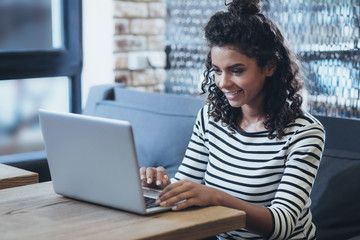 Modern work. Gay female freelancer typing while smiling