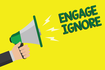 Text sign showing Engage Ignore. Conceptual photo Silent Treatment Manipulative Punishment Sulking Shunning Man holding megaphone loudspeaker yellow background message speaking loud