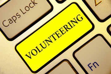 Text sign showing Volunteering. Conceptual photo Provide services for no financial gain Willingly Oblige Keyboard yellow key Intention create computer computing reflection document