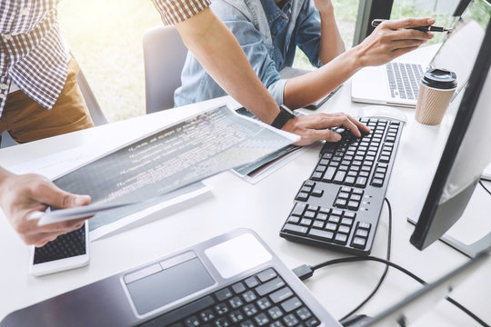 Programmers cooperating at Developing programming and website working in a software develop company office, writing codes and typing data code