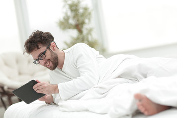closeup.sleepy man looking at the screen of a digital tablet.