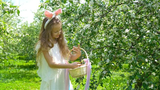 Adorable little girl in blooming apple garden on beautiful spring day