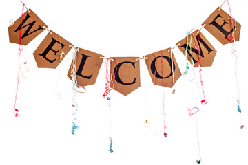 Welcome home party banner bunting with streamers against white background. The word welcome hanging on string.