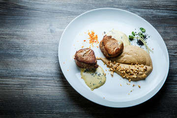 top view on two tasty pieces of grilled meat with puree and sauce