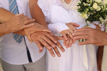 Obraz na płótnie Canvas hands of the bridegroom, the bride and their parents