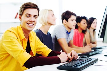 Group of Students with computers at lesson in classroom