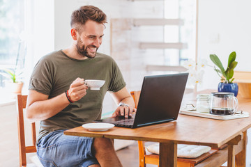 Young successful man working on laptop at home