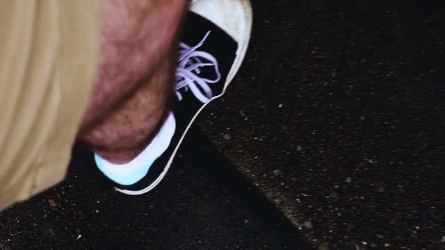 A set of legs with converse shoes on slowly makes their way up a few wet stairs