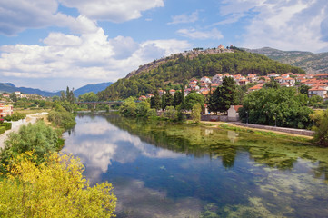 Fototapeta na wymiar Picturesque summer landscape. Ancient town on river bank. Bosnia and Herzegovina, Trebinje. View of Trebisnjica river and Crkvina Hill