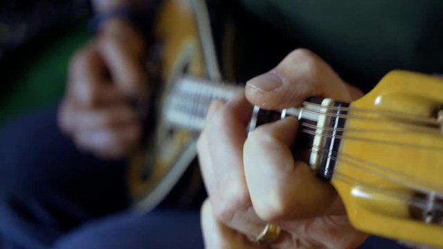Close slo mo clip of woman playing mandolin