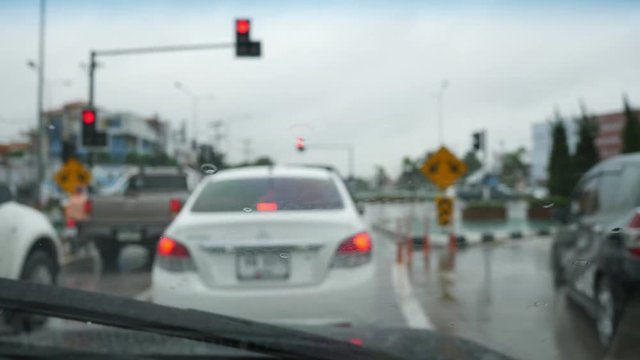 traffic jam in rainy day, slow motion wiper swing clearing rain on windshield