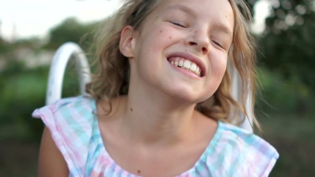 Closeup portrait of beautiful cute blondy caucasian little girl smiling and laughing while looking at camera. Real time full hd video footage