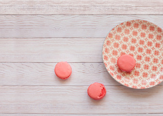 red macarons on wooden table with oriental plate