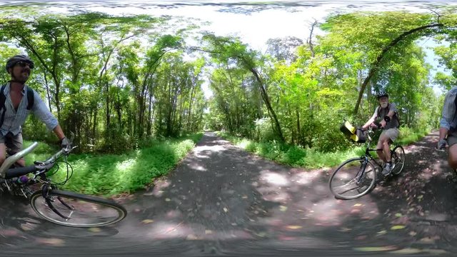 4K 360 vr of senior, elderly man bicycling on a rail trail on a sunny day.