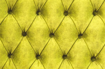 Velor surface of sofa close-up. Training equipment-velor mats tightened with buttons. Yellow chesterfield style quilted upholstery background close up