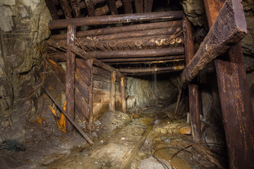 Fototapeta na wymiar Underground abandoned gold iron ore mine shaft tunnel gallery passage with timbering wooden