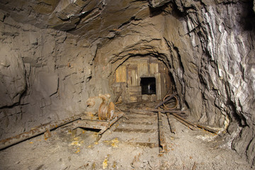 Underground abandoned gold iron ore mine shaft tunnel gallery passage with timbering wooden