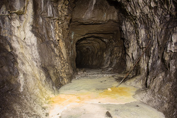 Underground abandoned gold iron ore mine shaft tunnel gallery passage with timbering wooden