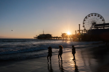 3 Mädchen am Strand im Sonnenuntergang vor Riesenrad