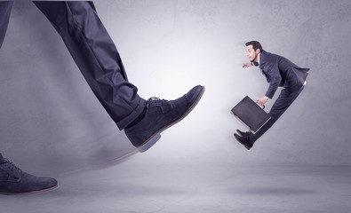 Deported from workplace, big foot kicking small businessman flying away
