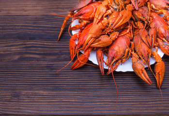 a large plate of boiled crawfish and a mug of light beer on a wooden background