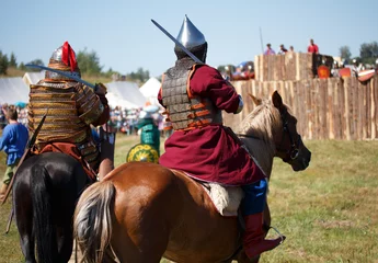 Foto op Plexiglas Reconstruction. Country. Medieval knight whith lance on horse from fantasy. Equestrian soldiers in historical costumes is in the military camp © valyalkin