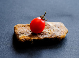 Small ripe tomato on the stone