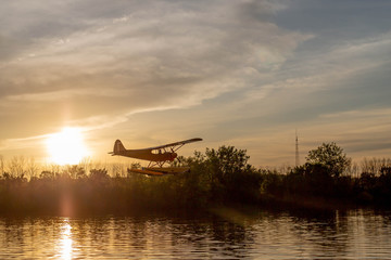 Plane over water during sunset