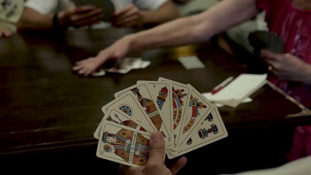 Group of people playing Briscola cards.