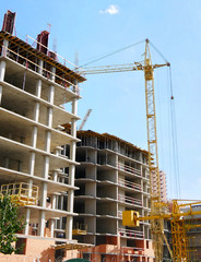 Construction sie background. Crane near concrete buildings under construction