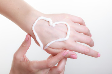 Cream on woman hand, heart shape