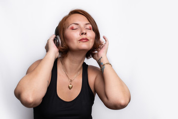 Fototapeta premium Girl wearing wireless headphones and listening to music with eyes closed