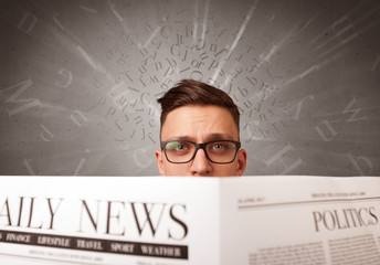 Young smart businessman reading daily newspaper with alphabet letters above his head
