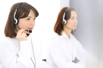 Call center. Group of operators at work. Focus on young brunette woman. Business  concept