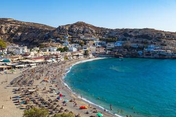 Obraz premium MATALA, CRETE - AUGUST 11: Matala beach with tourists at high peak sunner season.