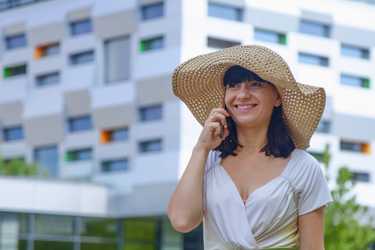 Portrait of young happy smiling businesswoman with smartphone outdoors as symbol of good news, freelance, success and wealth