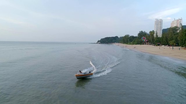 A slowmo shot of a boat driver preparing a landing of a Parasailer in Penang, Malaysia.
