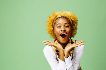 Excited young woman, isolated on green studio background