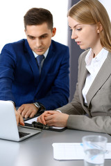 Business people using laptop pc while discussing project in office