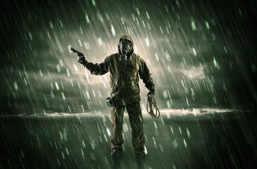 Terrorist in a stormy space with gas mask on his hand and weapons on his arm
