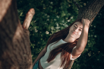 Naklejka premium Beautiful young smiling lady in park