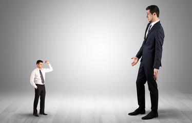 Big debutant young businessman scared of small strong businessman
