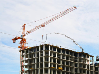 Skyscraper construction. Crane near concrete building under constriction. Construction site.