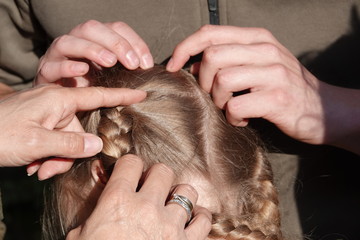 Checking a young girls hair for head lice