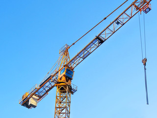 Self-erection crane against blue sky.