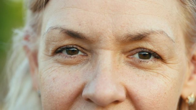 Extreme close up of Caucasian woman's eyes Middle aged white lookingcamera slow motion wisdom humanity